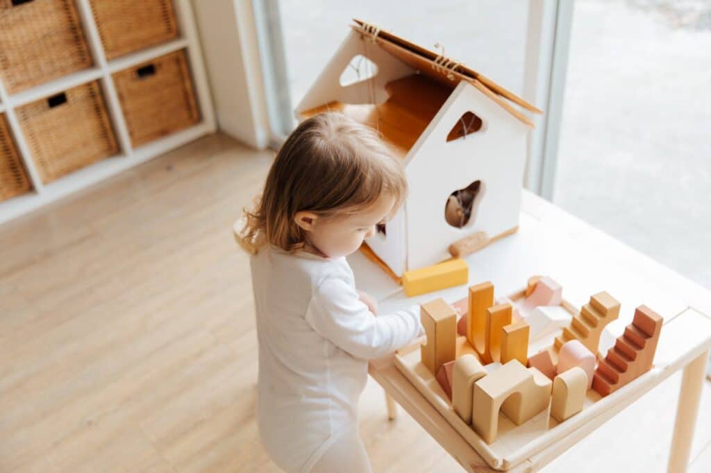 meisje met houten huisje